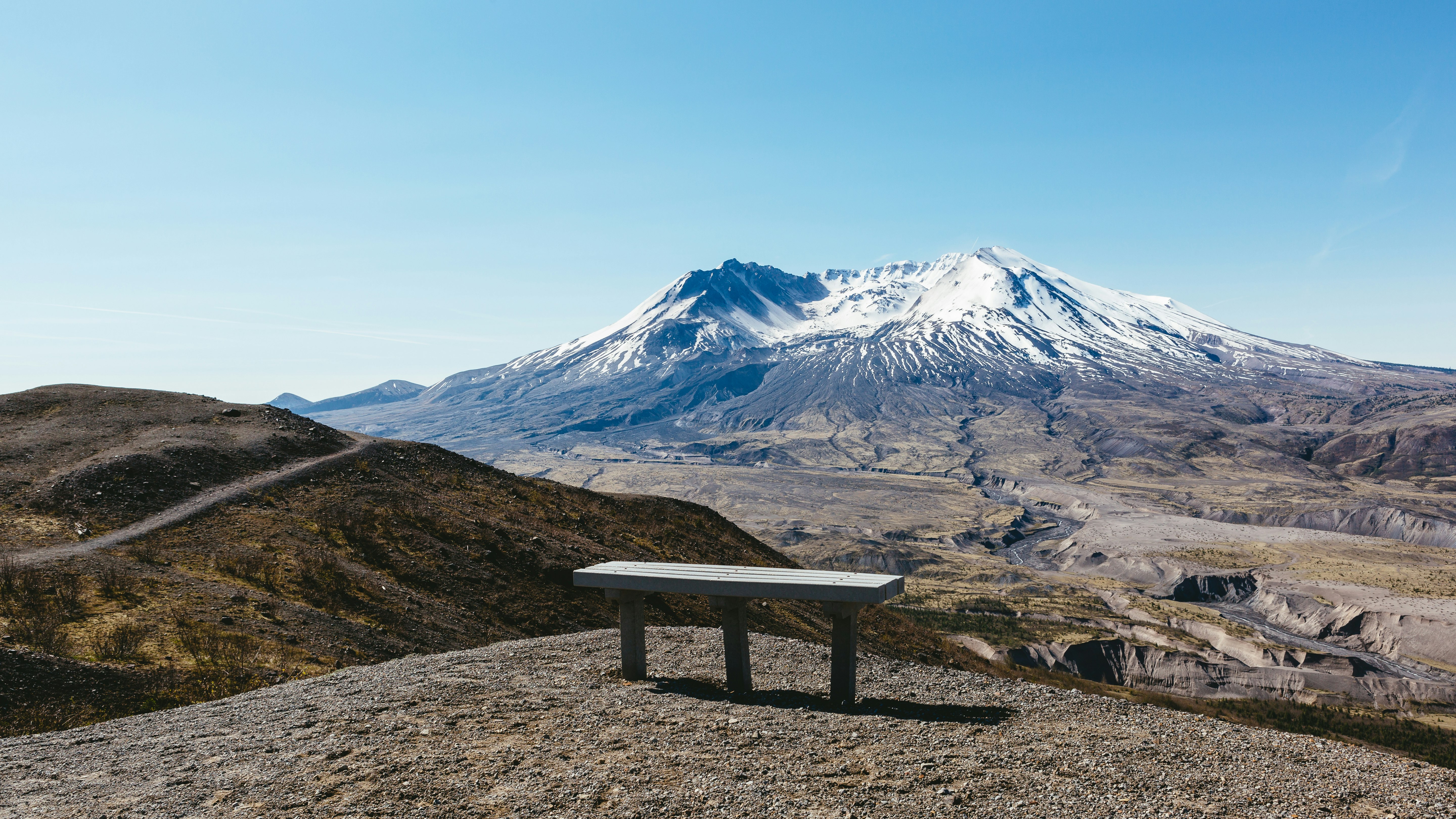 bench on gray ground near mountains